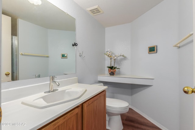 bathroom featuring vanity, wood-type flooring, and toilet