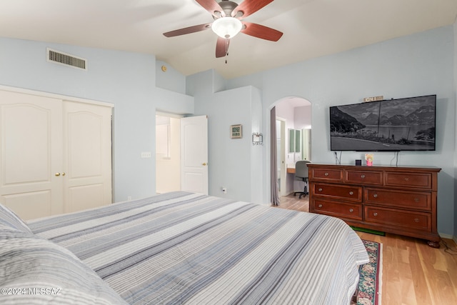 bedroom featuring ceiling fan, connected bathroom, light hardwood / wood-style floors, a closet, and lofted ceiling