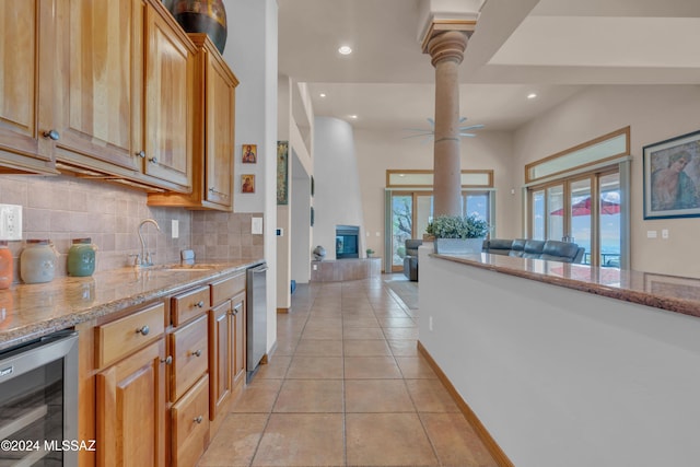 kitchen featuring sink, wine cooler, plenty of natural light, and light tile patterned flooring