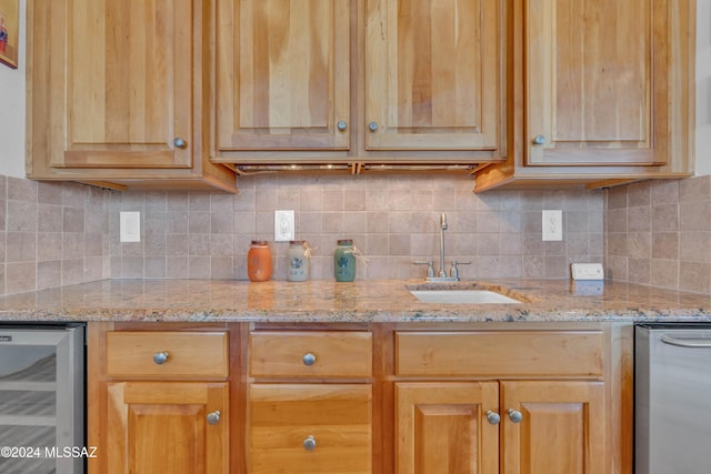 kitchen featuring decorative backsplash, light stone countertops, sink, and wine cooler