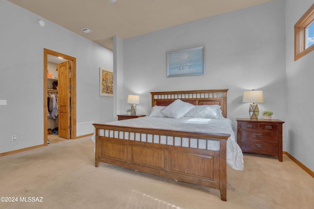 carpeted bedroom with a spacious closet and a closet