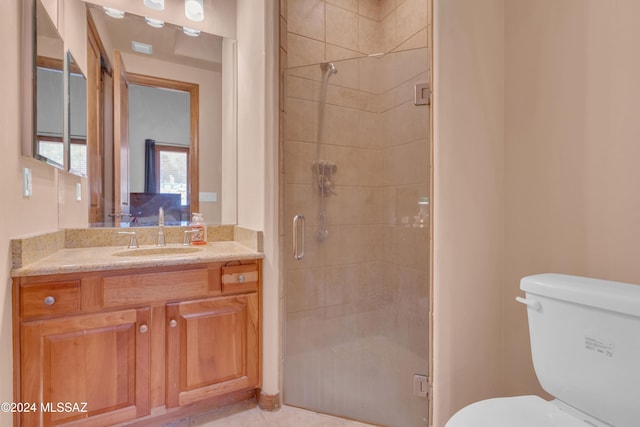 bathroom with tile patterned floors, vanity, toilet, and walk in shower