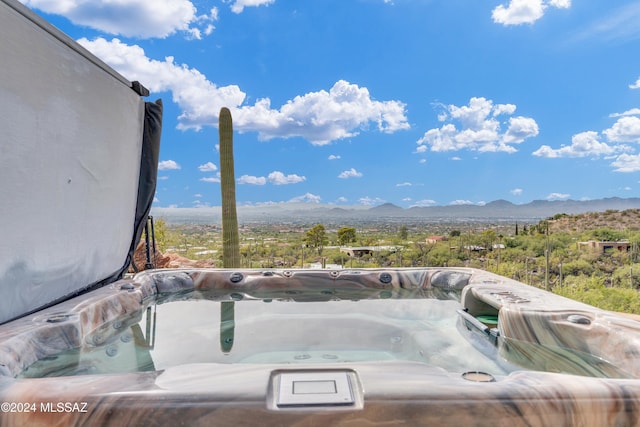 exterior space featuring a mountain view and a hot tub