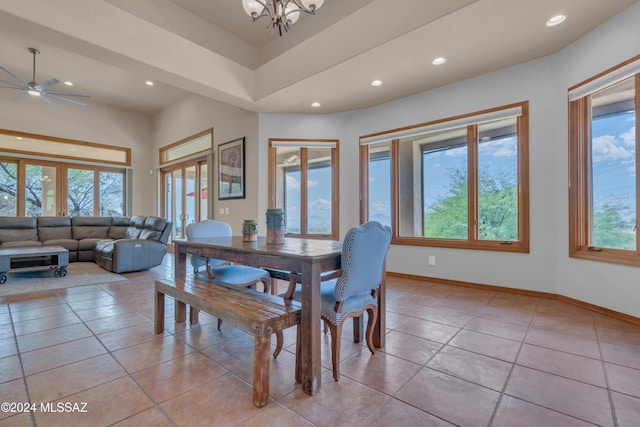 tiled dining area featuring ceiling fan with notable chandelier