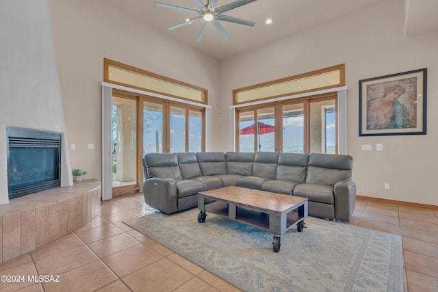 tiled living room featuring a tile fireplace and ceiling fan