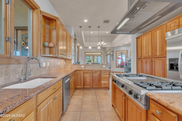 kitchen featuring backsplash, light stone counters, stainless steel appliances, sink, and a notable chandelier