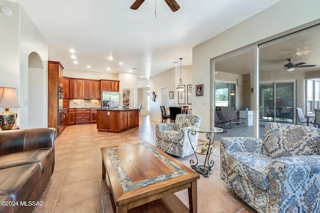 living room with light tile patterned floors, ceiling fan, and sink