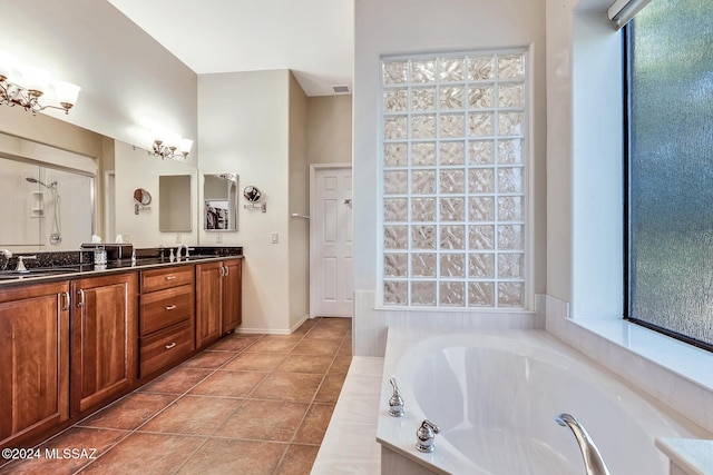 bathroom featuring vanity, tile patterned floors, and tiled tub