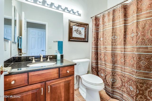 bathroom featuring curtained shower, tile patterned flooring, vanity, and toilet