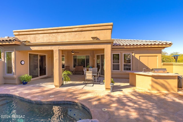 back of property with a patio area, ceiling fan, and area for grilling