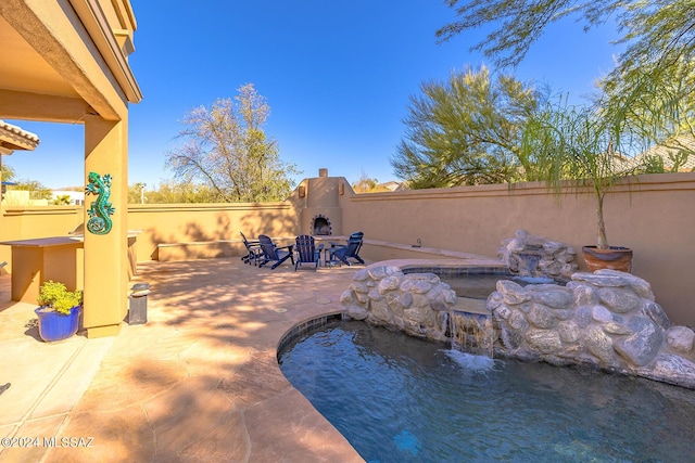 view of pool with a patio area and an outdoor fireplace