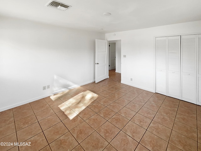 unfurnished bedroom featuring a closet and light tile patterned flooring