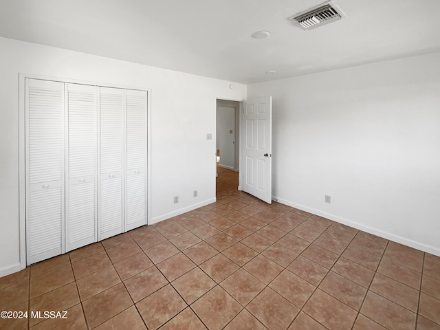 unfurnished bedroom with light tile patterned floors and a closet