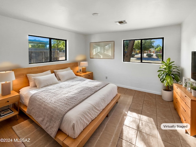 bedroom with multiple windows and light tile patterned floors