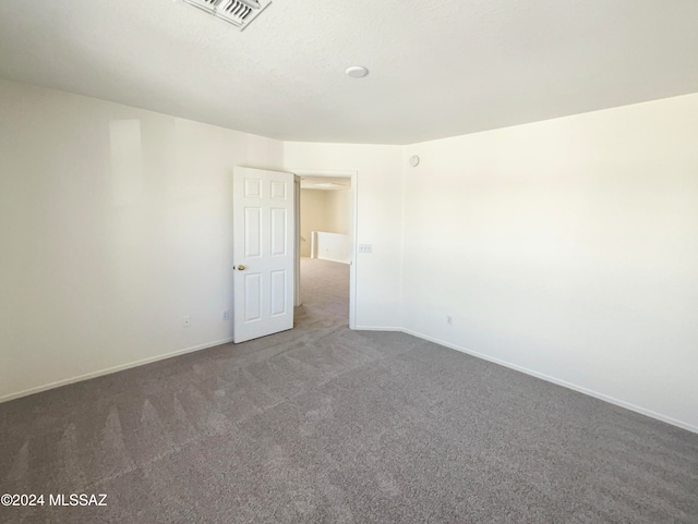 empty room featuring dark colored carpet