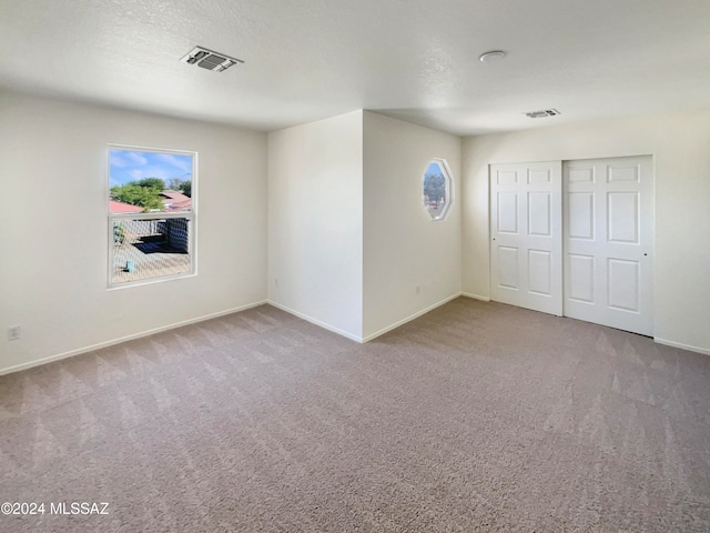 unfurnished bedroom with a closet, carpet floors, and a textured ceiling