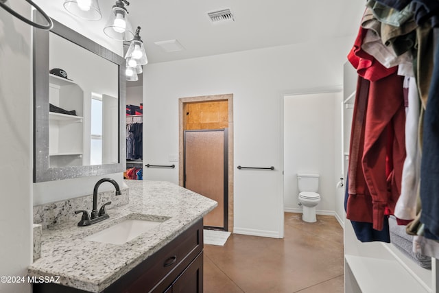 bathroom with vanity, an enclosed shower, and toilet