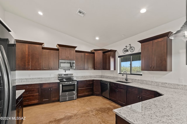 kitchen with lofted ceiling, sink, decorative light fixtures, light stone counters, and stainless steel appliances