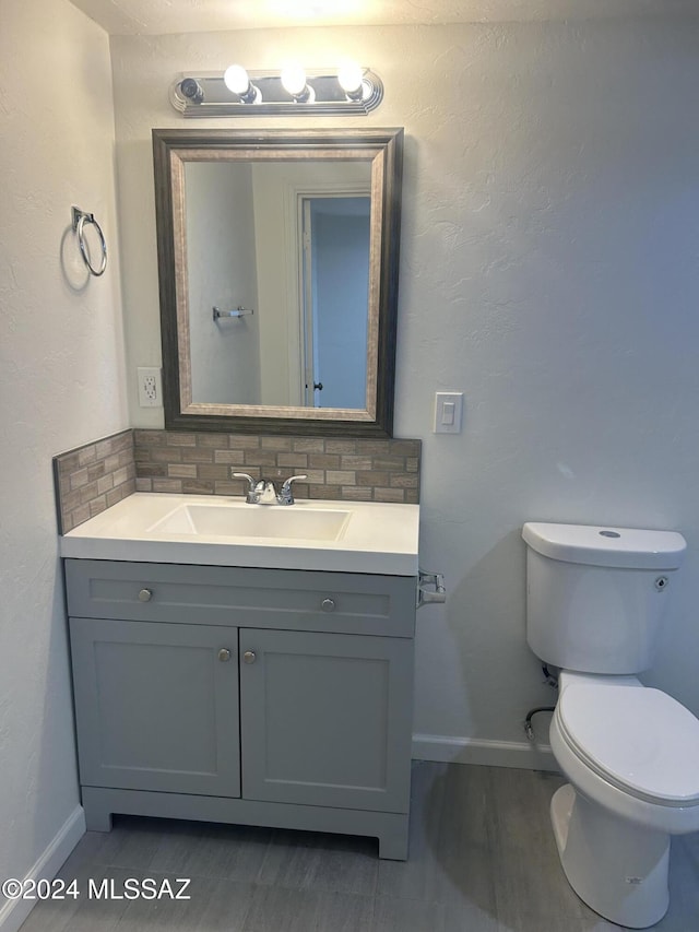 bathroom with decorative backsplash, hardwood / wood-style floors, vanity, and toilet