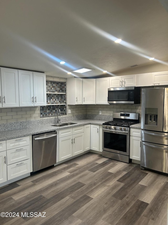 kitchen with white cabinetry, sink, tasteful backsplash, dark hardwood / wood-style floors, and appliances with stainless steel finishes