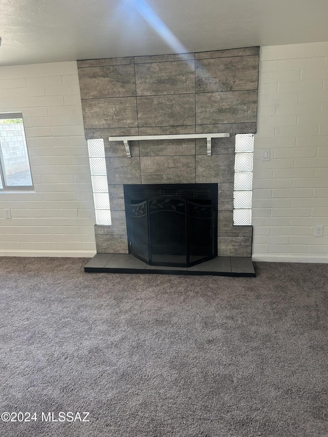 details featuring a tile fireplace and carpet