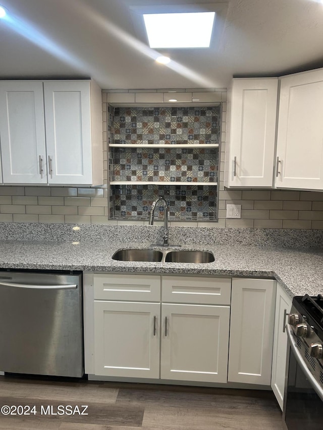 kitchen featuring white cabinetry, sink, dark wood-type flooring, backsplash, and appliances with stainless steel finishes