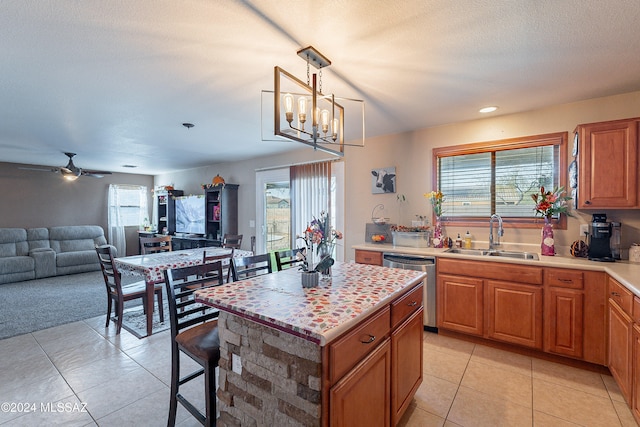 kitchen with pendant lighting, plenty of natural light, a center island, and sink