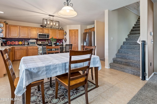 dining space featuring stairway, a chandelier, light tile patterned floors, and baseboards