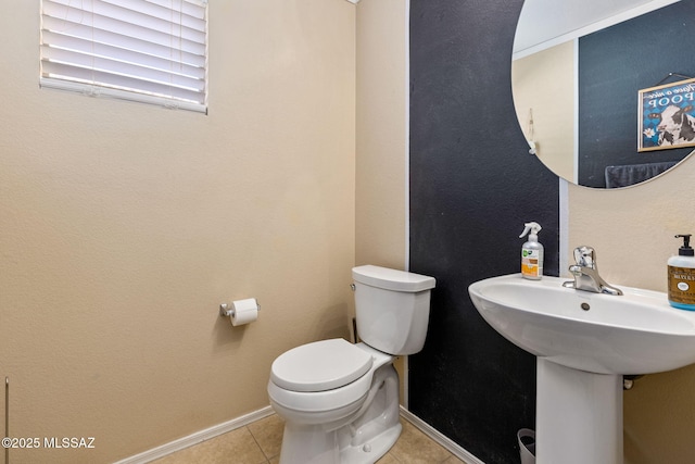 bathroom featuring toilet, tile patterned flooring, and baseboards