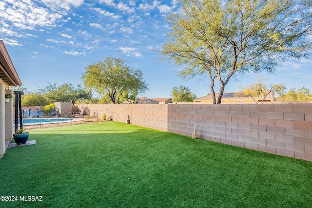 view of yard with a fenced in pool