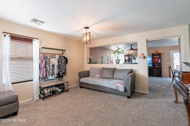 living room with carpet flooring and ceiling fan with notable chandelier