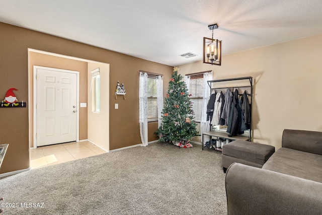 entrance foyer with light carpet, baseboards, and a chandelier