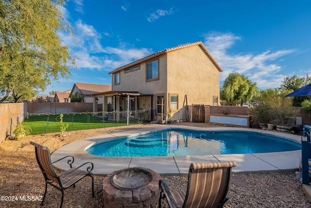 view of pool featuring a yard and a fire pit