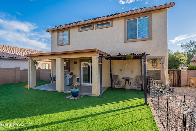 rear view of house with a pergola, a patio area, and a lawn