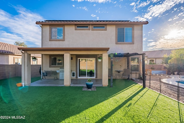 back of house featuring a pergola, a patio area, and a lawn