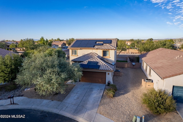 view of front of home featuring a garage and solar panels