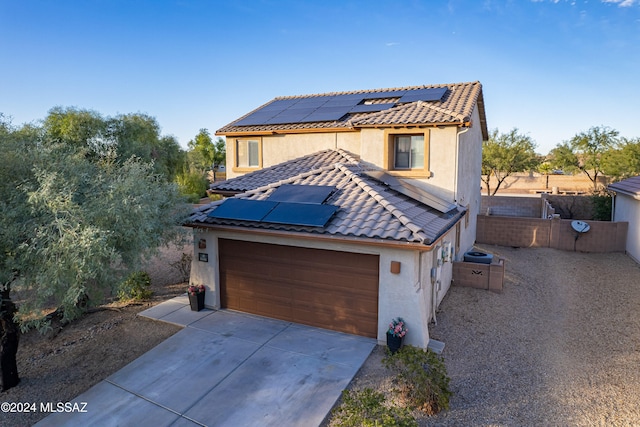 view of front facade featuring a garage and solar panels