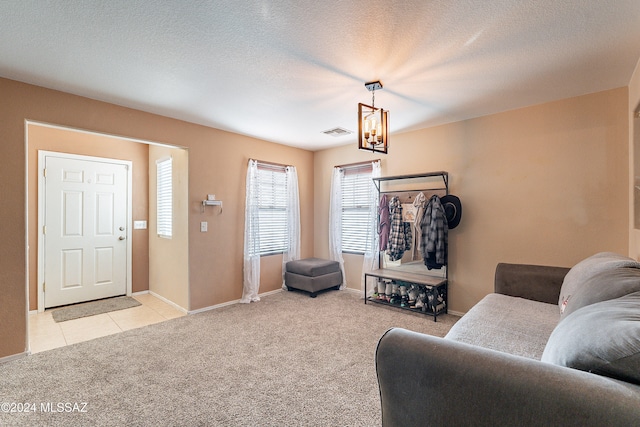 living room with light carpet, a textured ceiling, and an inviting chandelier