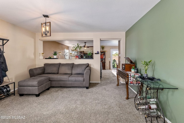 living area with carpet flooring, baseboards, and a chandelier