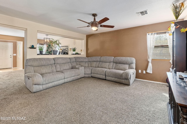 carpeted living room featuring a ceiling fan and baseboards