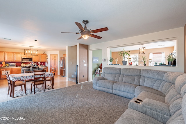 living room featuring light carpet and ceiling fan with notable chandelier