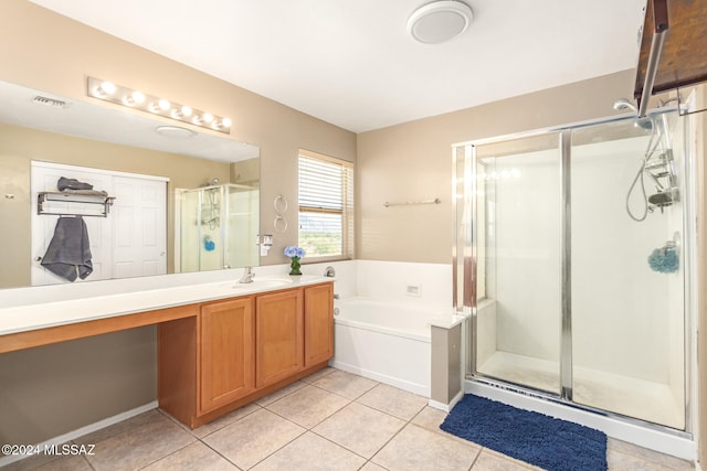 bathroom with tile patterned flooring, vanity, and shower with separate bathtub