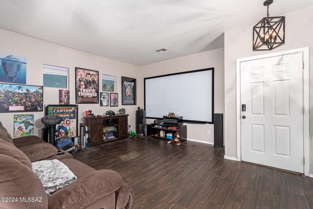 home theater room featuring dark hardwood / wood-style flooring and a notable chandelier