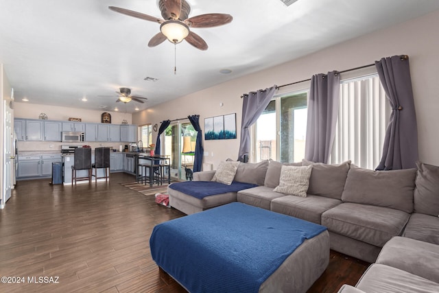 living room with ceiling fan and dark hardwood / wood-style flooring