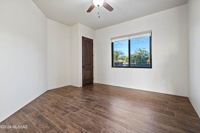 unfurnished room with dark wood finished floors and a ceiling fan