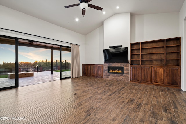 unfurnished living room featuring high vaulted ceiling, wood finished floors, recessed lighting, a stone fireplace, and ceiling fan
