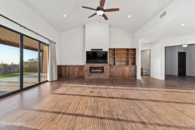 unfurnished living room with visible vents, ceiling fan, a fireplace, wood finished floors, and high vaulted ceiling