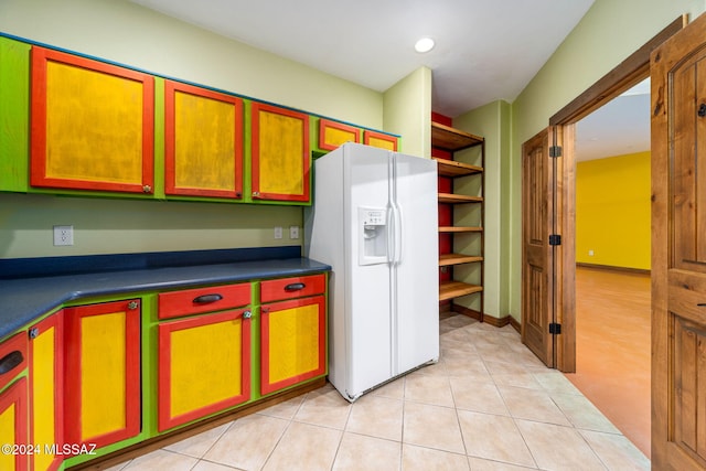 kitchen featuring light tile patterned floors and white fridge with ice dispenser