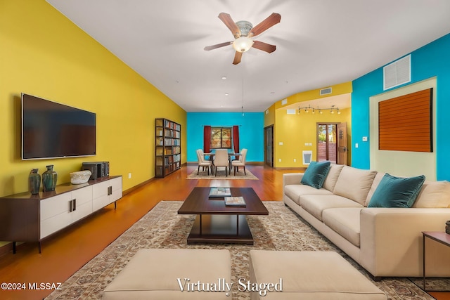 living room featuring ceiling fan, lofted ceiling, and light wood-type flooring