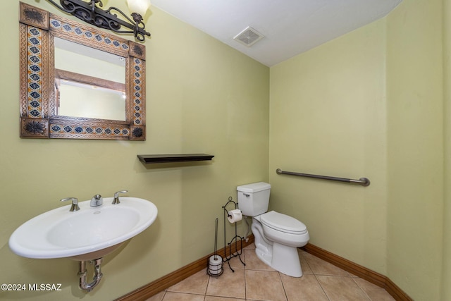 bathroom with toilet, tile patterned flooring, and sink